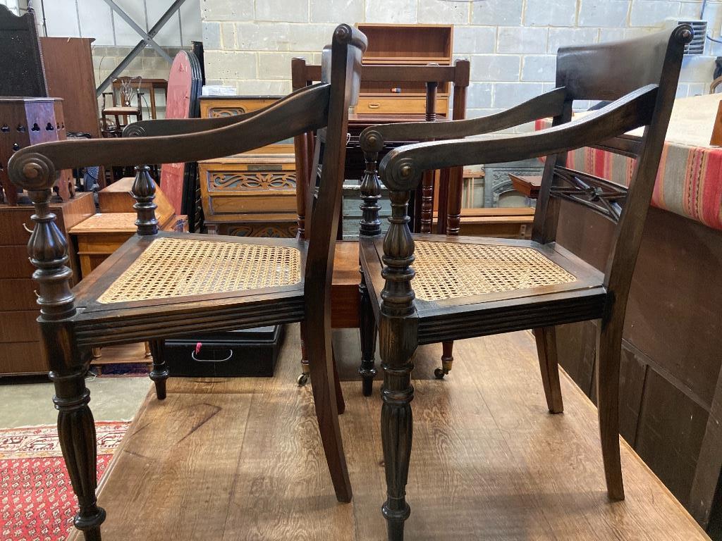 A pair of carved hardwood Anglo Indian elbow chairs with cane seats